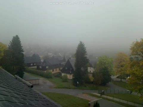 Seiffen: Nebel über dem Ort, erste Herbstbäume